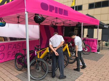 Pink 6x4 m Ecotent® folding tent with OPIUM branding and e-bike display.